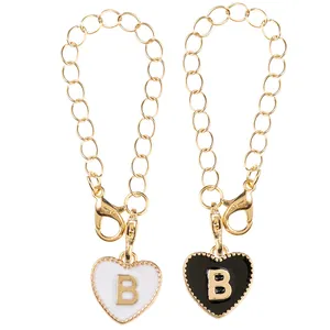 Golden keychain accessories with heart-shaped enamel B letter pendants in black and white