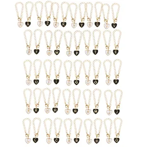 Close-up of 26 heart-shaped letter charms with gold-plated edges and lobster clasps
