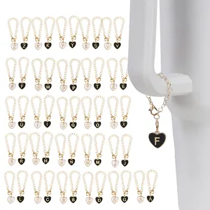 Detail of 26 heart-shaped alphabet charms with black and white enamel and gold chains