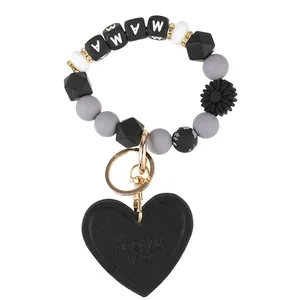 Macro shot of MAMA silicone beaded keychain wristlet with black leather heart charm