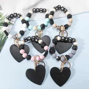Detail view of MAMA silicone beaded keyrings with heart leather charms and gold clasps