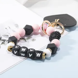 Detail of beaded keychain with pink and black silicone beads, MAMA letters and daisy charm