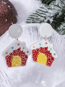 Close-up of creative acrylic gingerbread house earrings with festive holiday textures