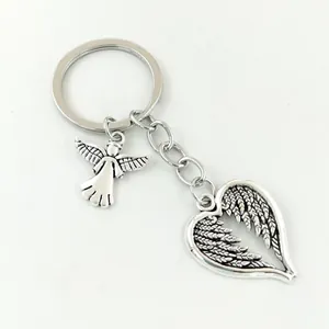 Detailed view of silver guardian angel and heart-shaped wing pendants on a metal keychain