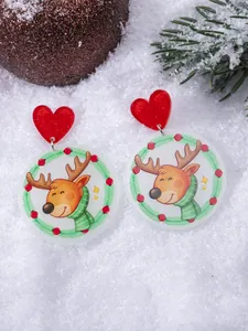 Detail shot of Christmas reindeer acrylic earrings on a festive snow background
