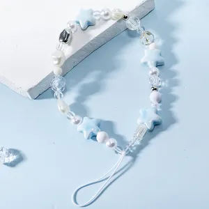 Detailed view of handmade beaded phone strap with star beads and blue fishbone accents