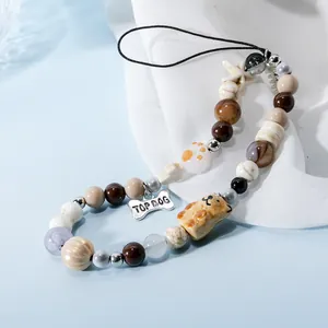 Macro shot of handmade beaded phone strap featuring a silver Top Dog bone metal charm