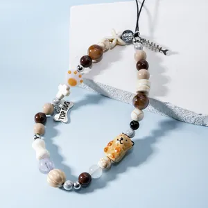 Detail of beaded phone strap with cartoon bear, fish bone and Top Dog charms