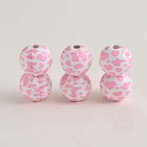 Close-up of pink cow print wooden beads for DIY farmhouse crafts and jewelry projects