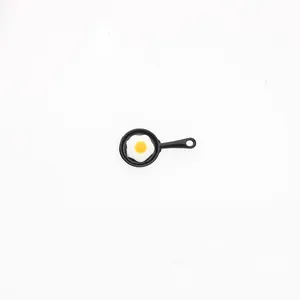 Detailed view of a miniature black frying pan charm with a realistic resin fried egg inlay