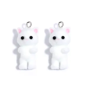 Close-up of white flocked cat charms with pink ears and silver rings for DIY jewelry