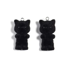 Detailed view of two cute black flocked cat charms with soft velvet texture and silver rings