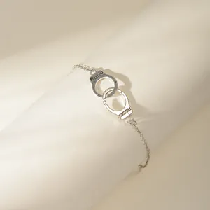 Minimalist silver anklet featuring interlocking handcuffs with Freedom engraving decoration