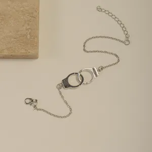 Detail view of silver handcuffs chain with FREEDOM engraving and adjustable clasp
