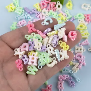 Close-up van parelmoer macaron letterkralen met oogjes voor DIY sieraden maken hobby
