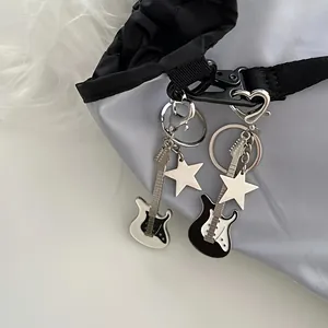 Set portachiavi mini chitarra elettrica con stelle su tracolla di zaino grigio