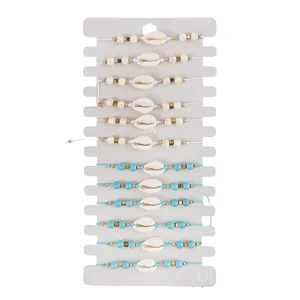 Set di 12 bracciali boho con conchiglie e perline turchesi su cartoncino da esposizione