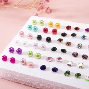 Close-up of assorted colorful resin fruit and rhinestone stud earrings on white board
