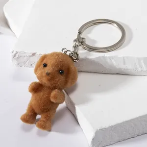 Close-up of a brown flocked poodle dog keychain with soft fur texture and silver metal ring