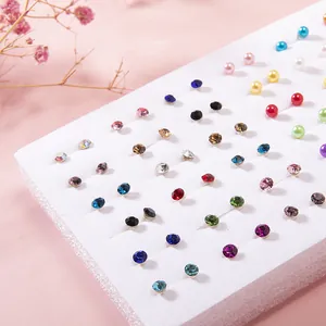 Detailed view of 36 pairs of colorful resin crystal stud earrings on display board