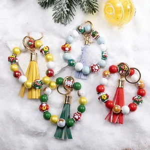 Christmas silicone bead keychains with Santa Claus patterns, tassels, and snow background