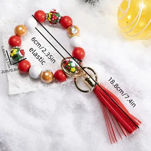 Detail of elastic Christmas beaded keychain with red tassels and festive snowmen patterns
