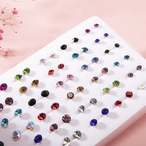 Macro detail of multi-color round rhinestone stud earrings set in white foam display