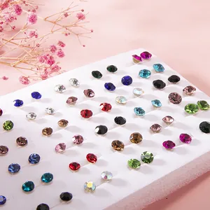 Close-up of colorful resin rhinestone stud earrings set on a white foam display board