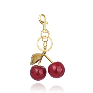 Sparkly red cherry keychain with gold metal clasp for bags and stylish key organization