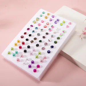 36 pairs of colorful resin fruit and crystal stud earrings for children on display
