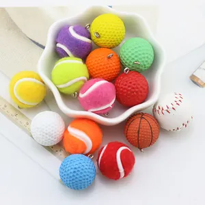 Close-up of mini tennis and golf ball keychain charms in a decorative white bowl
