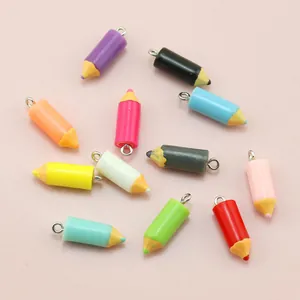Close-up of colorful pencil-shaped resin charms with metal loops for DIY jewelry making