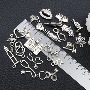 Macro-opname van antieke zilveren medische bedeltjes zoals stethoscoop voor DIY-sieraden