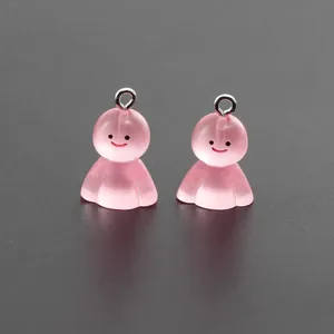 Close-up of two pink translucent resin ghost charms with silver rings for DIY jewelry