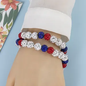 Détail d'un bracelet double couche avec des perles de strass rouges, blanches et bleues