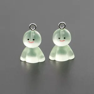Close-up of two light green translucent resin ghost charms with metal keyrings