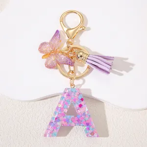 Resin letter A keychain with pink sequins, purple tassel, and butterfly charm