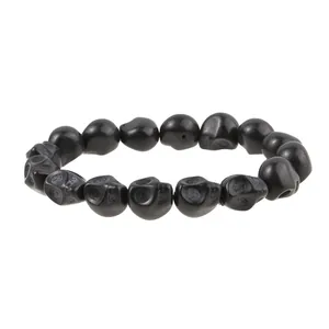 Detailed close-up of matte black skull beads on a punk style stretch bracelet