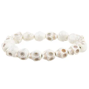 Macro shot of white howlite skull beads with detailed engravings on the stretch bracelet