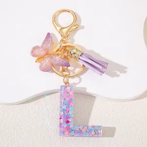 Detailed macro view of purple resin letter L keychain with heart sequins and butterfly