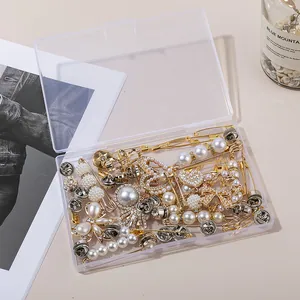 Assorted DIY jewelry charms including pearl bows and rhinestone hearts in clear storage box