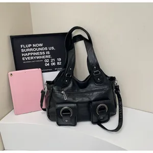Detail of black pebbled leather tote bag with silver ring buckles on front pockets