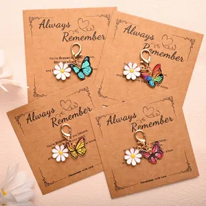Vue détaillée de quatre pendentifs papillon et marguerite sur des cartes en kraft