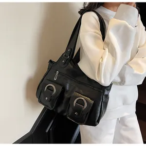 Detail of black tote bag with dual front pockets and metallic ring buckles design