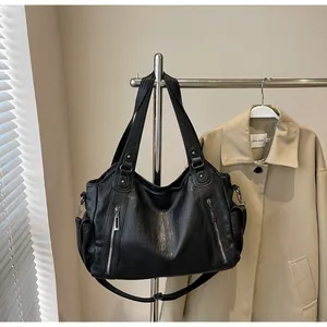 Detail of black pebbled PU leather tote with silver zippers and spacious side pockets