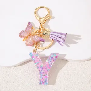 Detail of pink resin letter Y keychain with glitter heart sequins and purple tassel