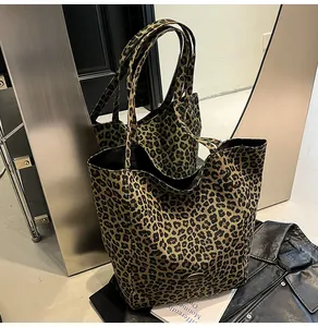 Detail of leopard print tote bag placed on black leather jacket and fashion magazine