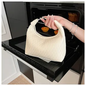 Detail einer cremeweißen Hobo-Tasche mit Falten-Design und weicher gewellter Textur-Optik