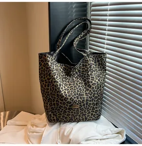 Close-up of leopard print canvas tote bag with gold logo and elegant light shadows