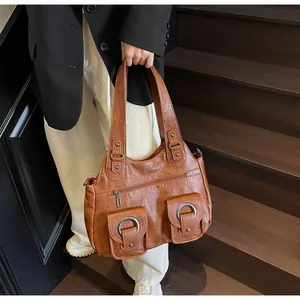 Detail of dark brown retro tote bag featuring twin front pockets and silver ring buckles